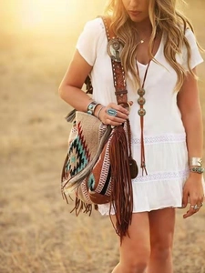 Detail showing colorful geometric woven bag with long leather tassels in boho style