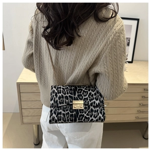Detailaufnahme der Schultertasche mit Leopardenmuster und goldener Kette am Model