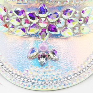 Dettaglio macro di cappello in pelle PU cangiante con strass e decorazioni di perle