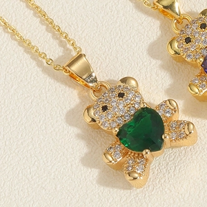 Dettaglio del ciondolo a orso con pavé di zirconi bianchi e pietra centrale a cuore verde