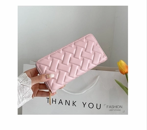 Pink long zip-around purse with embossed texture held against a stylish gift background