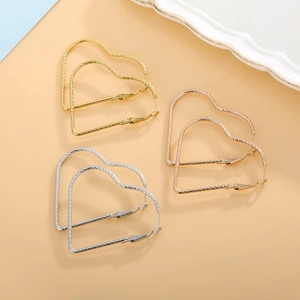 Detailed macro view of large textured heart earrings in gold, silver and rose gold