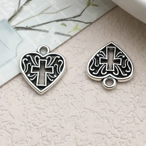 Vue détaillée des pendentifs cœur et croix en argent antique pour création de bijoux