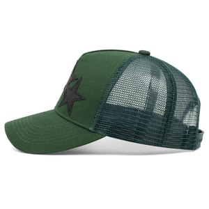 Side view of forest green trucker hat with breathable mesh and black star patch
