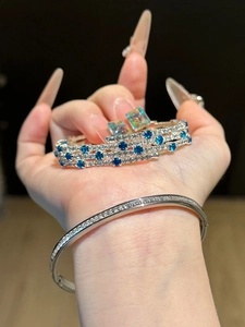 Close-up of three-layer silver bangle and bracelet with sparkling blue and white zircons