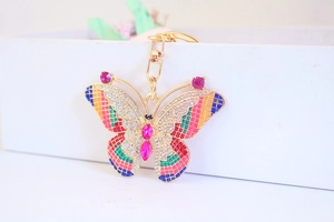 Macro shot of colorful enamel butterfly keychain with gold finish and sparkling rhinestones