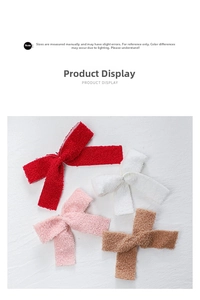 Close-up of four plush felt bow charms in red, white, pink and brown for Christmas decor