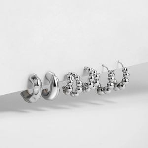 Detailed set of three stainless steel C-shaped hoop earrings with polished metal spheres