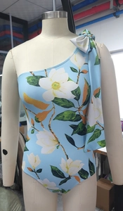Detail of light blue floral one-shoulder swimsuit with elegant bow knot on the shoulder