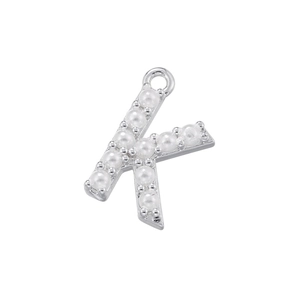 Detailed view of K-shaped pendant with silver metal frame and inlaid white pearls