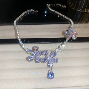 Detailed view of silver flower necklace with zircon pavé chain and waterdrop pendant