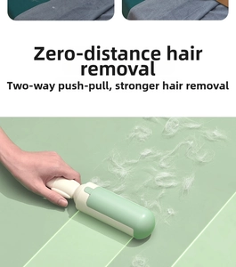 Detail of green handheld pet hair remover brush with bidirectional push-pull cleaning action