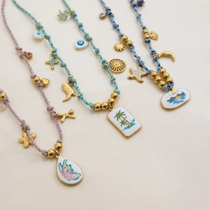Handmade woven necklaces with gold charms like butterfly, evil eye, and beach enamel pendants