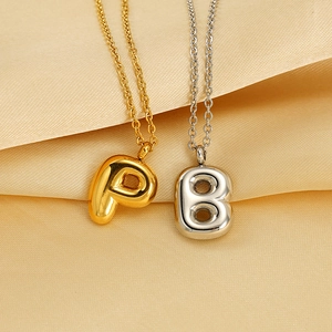 Polished bubble initial necklaces in gold and silver finish with elegant satin background
