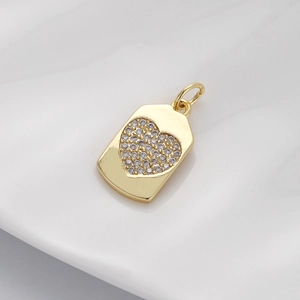 Detailed close-up of a gold shield pendant with a sparkling zircon inlaid heart motif