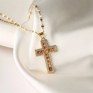 Macro shot of gold cross necklace with amber gemstone and clear cubic zirconia on silk