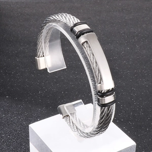 Macro detail of men's steel braided bracelet with a polished rectangular metal plate