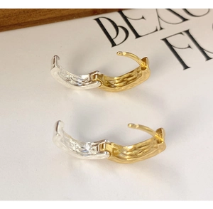 Macro shot of S925 sterling silver square earrings with gold lava texture and metal stamps