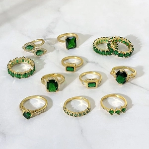 Ensemble de 11 bagues plaquées or 18 carats avec zircon vert émeraude sur marbre