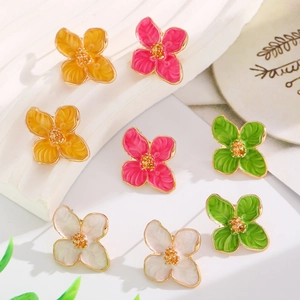 Detail of colorful enamel flower earrings in orange, pink, green, and white colors