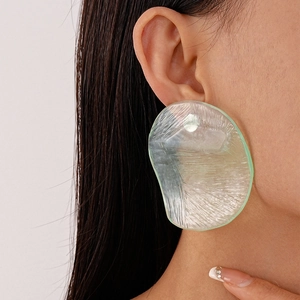 Close-up of a green translucent resin earring with an irregular wavy texture on a model