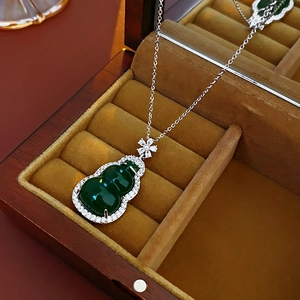 Detail view of a vintage silver necklace with green zircon gourd pendant in a gift box
