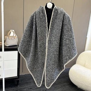 Detail of dark grey tweed shawl featuring cream decorative stitching and open-front design