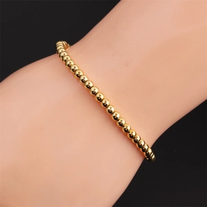 Elastic gold plated bead bracelet for women featuring smooth polished metallic spheres