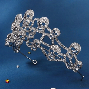 Detailed view of a silver-tone crown featuring sparkling rhinestones and skull patterns