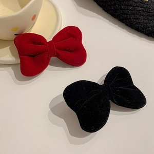 Detail of red and black velvet bow hair clips for girls with soft plush texture