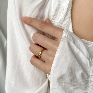 Close-up of a gold dome ring featuring three star-set zircon stones on model's hand