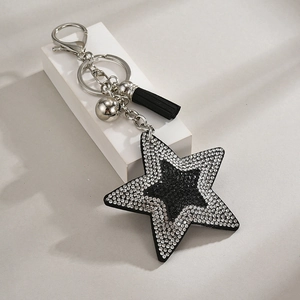 Detail of a black sequin star keychain with sparkling rhinestones and a black fringe tassel