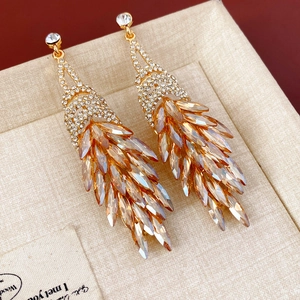 Gros plan de boucles d'oreilles en cristal champagne avec diamants sur fond de lin beige