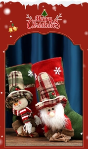 Detail of Christmas stockings with snowman and Santa dolls on a rustic wooden background
