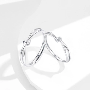 Minimalist Mobius knot silver couple rings set with zircons in professional studio lighting
