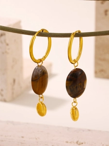 Close-up of gold stainless steel tiger eye earring with lucky engraving on branch