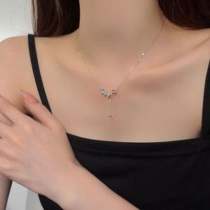 Macro detail of leaf pendant with pave crystals and elegant dangling chain on model neck