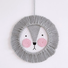 Macro detail of a handmade macrame lion wall hanging with gray cotton rope fringe
