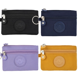 Detail of four colorful nylon coin purses with double zippers and metal keyrings