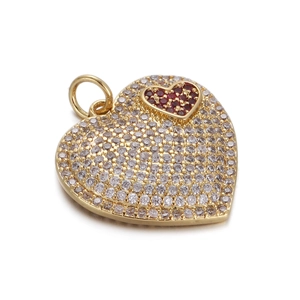 Detailed view of gold heart pendant with red center stone and pavé clear zircon accents