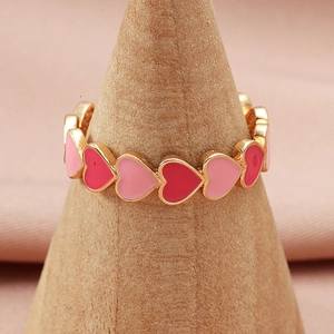 Anello a cuore regolabile placcato oro con smalto rosa e rosso su supporto in legno