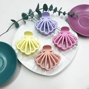 Detail of four matte fan-shaped hair claws in purple, yellow, pink, and mauve colors