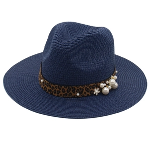 Detail of navy straw hat with leopard print ribbon and elegant pearl embellishments