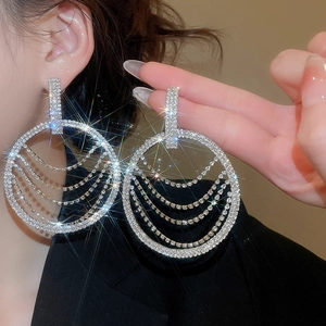 Gros plan de boucles d'oreilles pendantes en strass argentés portées par un mannequin