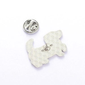 Macro shot of silver metal dog brooch back with honeycomb texture and butterfly clasp