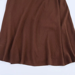 Deep brown linen blend dress fabric detail showing tight weave texture and soft pleats