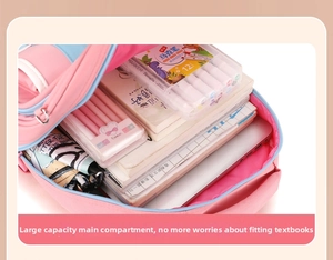 Detailed interior of a pink and blue school bag showing spacious compartments with stationery