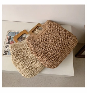 Detailed view of woven straw tote bags with square wooden handles in two natural beige tones