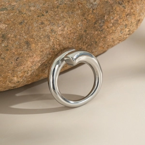 Close-up of silver polished stainless steel ring with minimalist overlapping open design