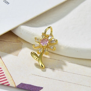 Macro detail of sunflower pendant with pink and white zircon in gold plating